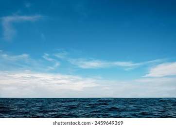 Beautiful nature view bright blue sky with white clouds background and soft oceans waves with a deep blue color on the sea