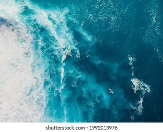 Blue ocean with waves and foam. Aerial view with surfer and sea background
