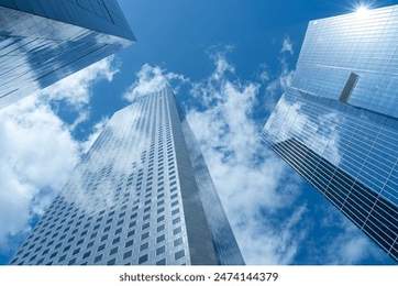 Looking Up modern high-rise office buildings with blue sky in the background.
