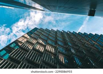 two modern office building and a dark blue sky and white fluffy clouds