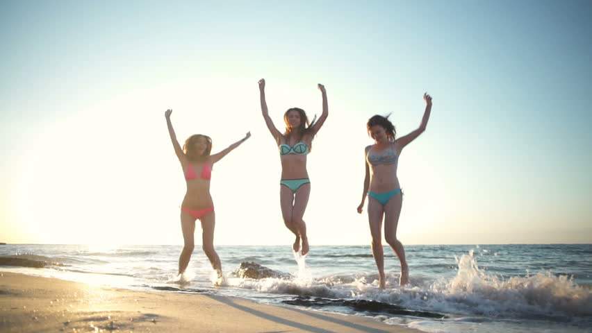 18three. young happy girls jumping up and down at sea side slow motion. hd0...